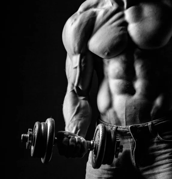 Man training with weight in dramatic studio light