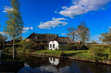 GIETHOORN, NETHERLANDS - evlerin ve bahçelerin tipik Hollanda ilçesi