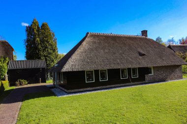 GIETHOORN, NETHERLANDS - evlerin ve bahçelerin tipik Hollanda ilçesi