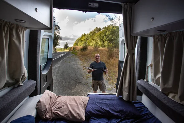 Yeni Zelanda 'da karavanın yanında İHA taşıyan adamlar.