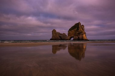 Wharariki Sahili, Yeni Zelanda 'da fil kayası. Gün batımı