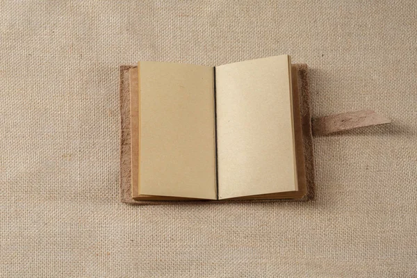 荒布表面で横になっているノートブックを開く — ストック写真