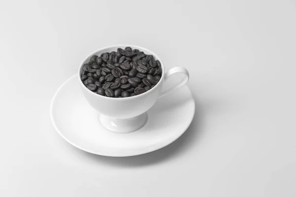 Grãos de café com em xícara de café no fundo branco — Fotografia de Stock
