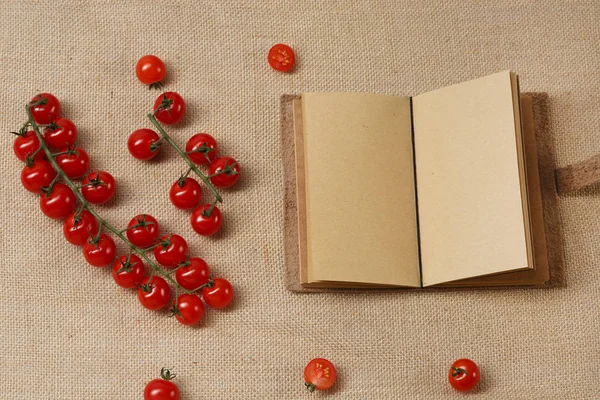 チェリー トマトのフェットチーネと開いているノートブック — ストック写真