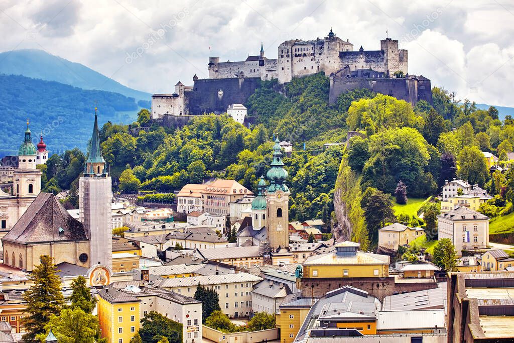 The Aerial panoramic view of the historic city of Salzburg with Salzach river in beautiful golden evening light with blue sky and clouds at sunset in summer, Salzburger Land, Austria