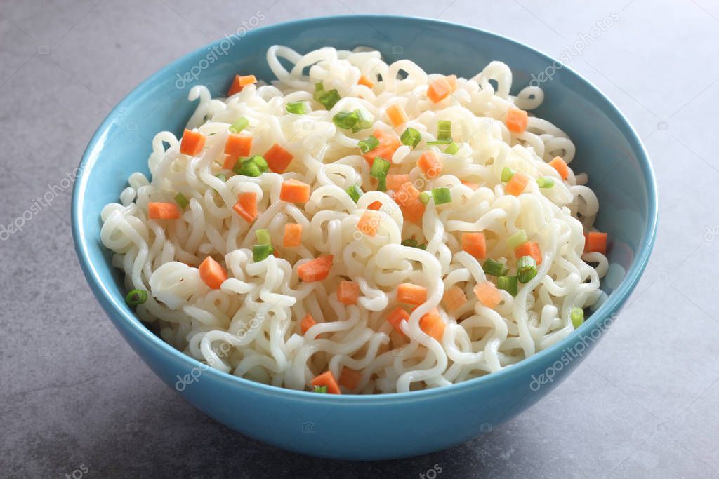 Instant noodles in a bowl isolated on dark background.