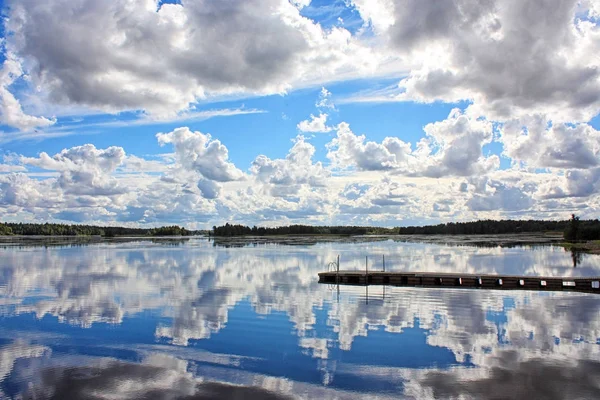 Molnig himmel speglar på vattnet — Stockfoto