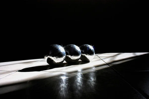 三银闪闪发光的球躺在白色的瓷砖 光影游戏 — 图库照片