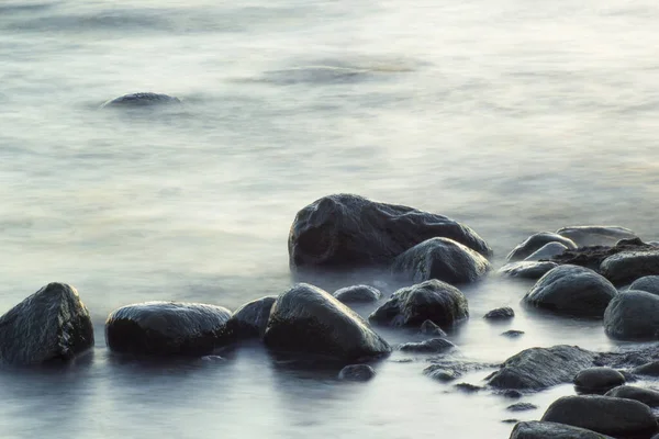 海と岩の長い露出 波が滑らかな海から突き出た岩 静物画 — ストック写真