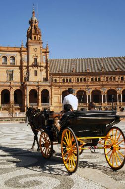 Seville (Sevilla), İspanya (Plaza de Espana) İspanya meydanında Sarayı önünde turists ile sarı tekerlekli taşıma