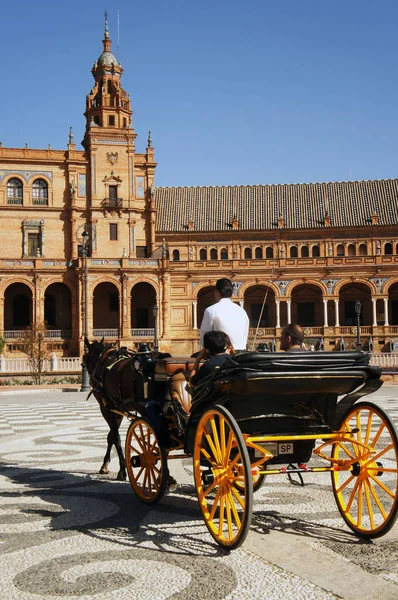 Transporte con ruedas amarillas con turistas frente al palacio en la Plaza de España en Sevilla (Sevilla), España — Foto de Stock