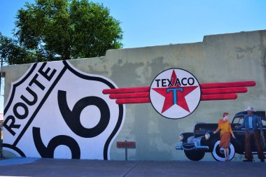 Tucumcari'deki, New Mexico - 21 Temmuz 2017: Texaco benzin istasyonunda Tucumcari'deki, eski bir Chrysler, Texaco logo, bir Route 66 işaret, bir kadın ve bir kovboy bir binanın yan tarafında gösterilen