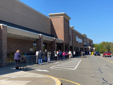 WOODBRIDGE, NEW JERSEY / USA - 7 Mayıs 2020: Müşteriler salgın sırasında Covid-19 sosyal mesafeleme kılavuzunun bir parçası olan Wegmans süpermarketine girmek için kuyrukta bekliyorlar