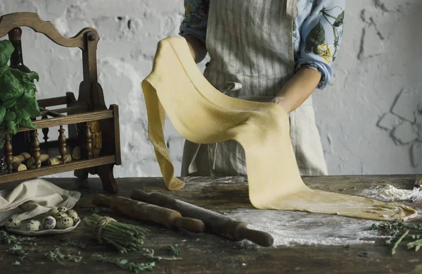 Young woman rolls out the dough for homemade pasta — Stock Photo, Image