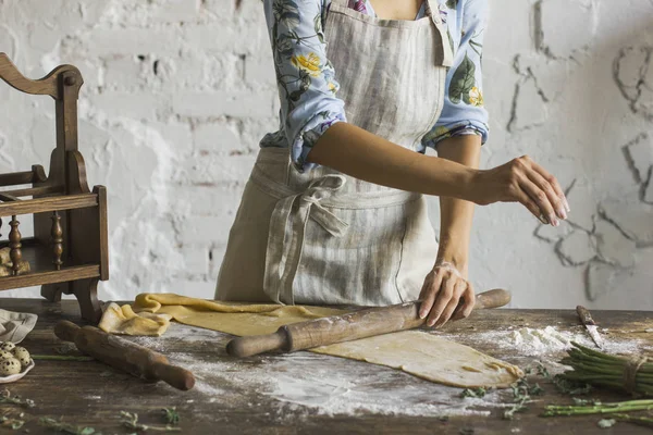 Young woman in a beautiful dress and an apron preparing the dough — Stock Photo, Image