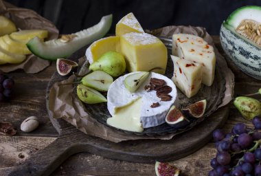 Farklı peynir ve eski ahşap zemin üzerine taze meyve