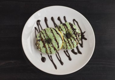 Çikolata siyah masada beyaz plaka ile drizzled şamfıstıklı çörekler