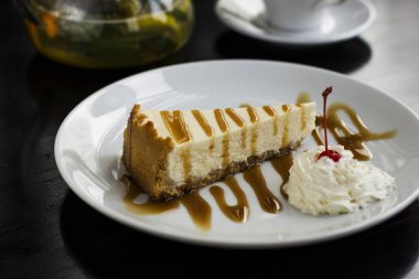 Cheesecake beyaz tabakta karamel ile drizzled