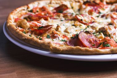 Salam ahşap arka plan üzerinde taze pişmiş pizza