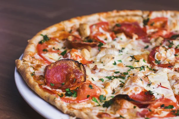 Salam ahşap arka plan üzerinde taze pişmiş pizza