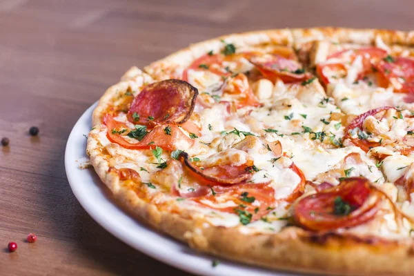 Salam ahşap arka plan üzerinde taze pişmiş pizza