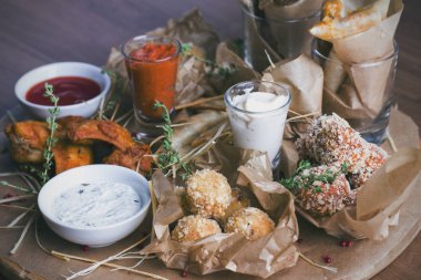 Peynir topları tempura, baharatlı tavuk kanadı ve çeşitli atıştırmalıklar