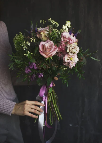 Красивый деревенский букет цветов в руках женщины — стоковое фото
