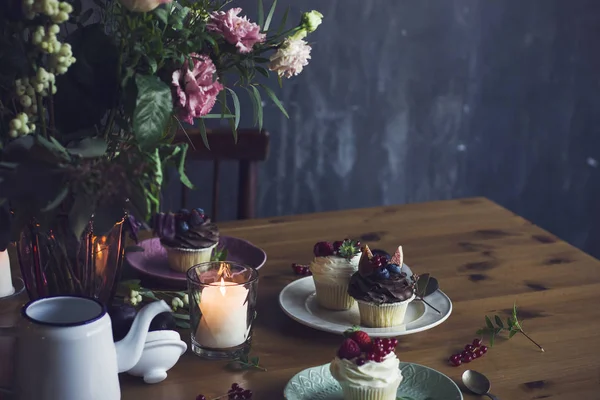La hermosa mesa festiva con ramo rústico, cupcakes y velas — Foto de Stock