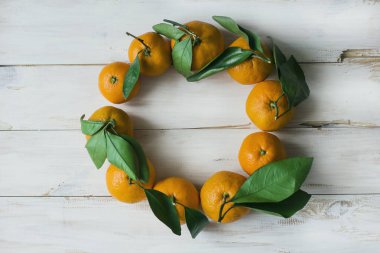 Beyaz ahşap zemin üzerinde çelenk taze mandalina 