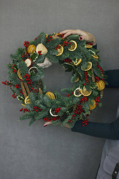 Рождественский еловый венок в женских руках

