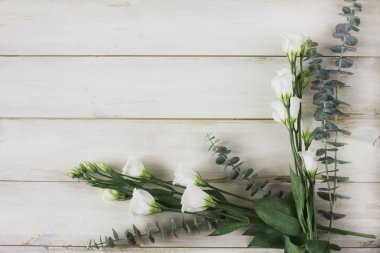 Beyaz ahşap zemin üzerinde Eustoma ve okaliptüs çiçekler