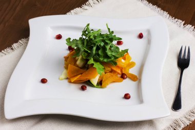 Elma ve bir kare plaka üzerinde nar meyve salatası