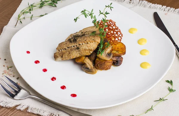 Baked fish with potatoes and mushrooms on a white plate — Stock Photo, Image