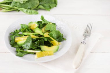 Ham salata, ıspanak, avokado ve portakal Beyaz ahşap zemin üzerinde