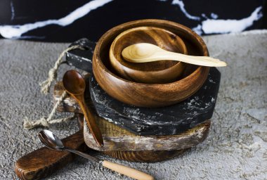 Ahşap panoları, kase ve gri beton zemin üzerine kaşık