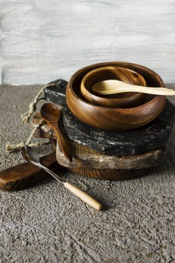 Ahşap panoları, kase ve gri beton zemin üzerine kaşık