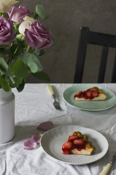 花とイチゴのパイ、素朴なスタイルのダイニング テーブル — ストック写真