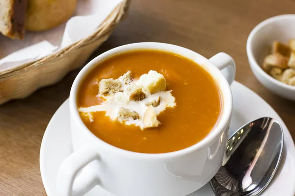 Томатный суп из пюре со сливками и крекерами в белой тарелке — стоковое фото