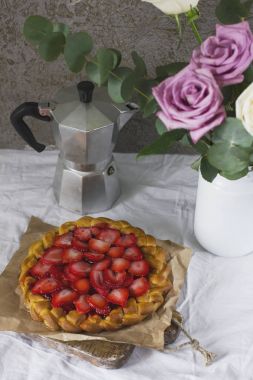 Çiçekler, kahve makinesi ve Çilekli pasta yemek masası