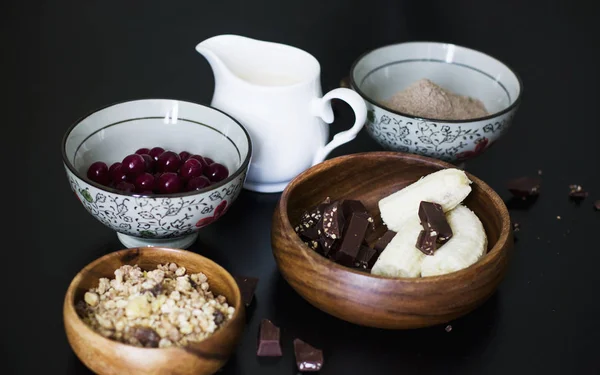 Zutaten für Muffins: Milch, Müsli, gefrorene Kirschen, Leinmehl, Bananen und Schokolade — Stockfoto