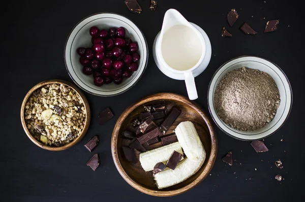 Muffins ingredients: milk, muesli, frozen cherry, flax flour, banana and chocolate — Stock Photo, Image