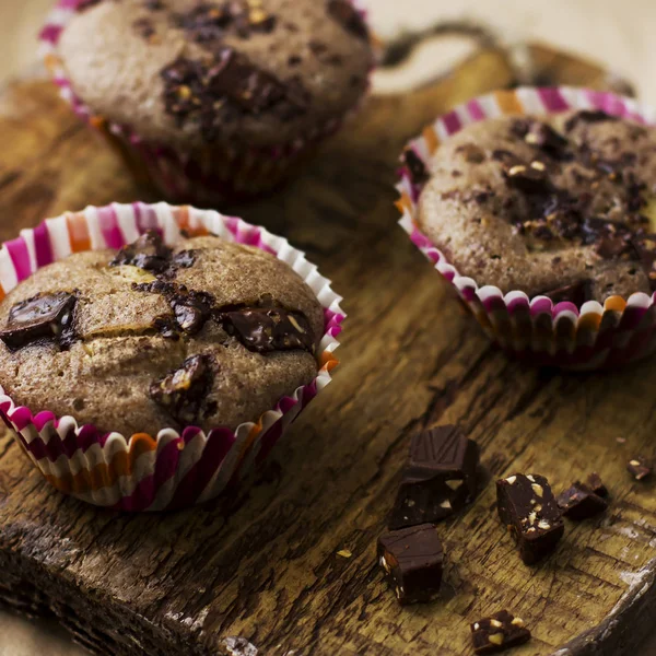 Muffins caseiros com chocolate em uma placa de madeira velha — Fotografia de Stock