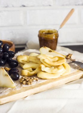 Peynir, bal, üzüm, armut ve fındık ahşap tahta üzerinde dize 