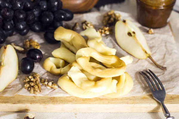 Homemade string Cheese, honey, grapes, pears and nuts on wooden board