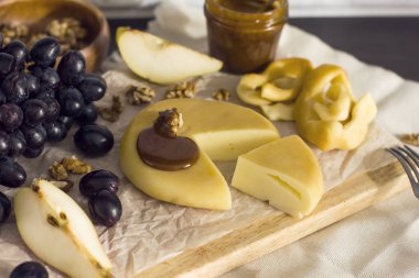 Peynir, bal, üzüm, armut ve mutfak ahşap tahta fındık