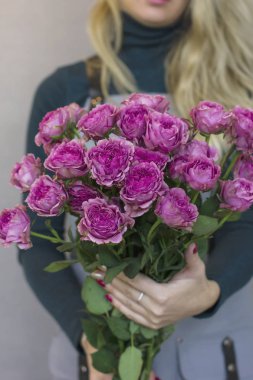 Büyük gri arka plan üzerinde kadın elinde pembe gül buketi