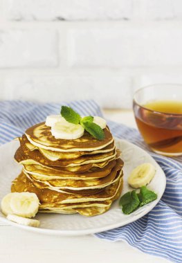 taze pişmiş krep muz beyaz tabak ve bardak çay ile 
