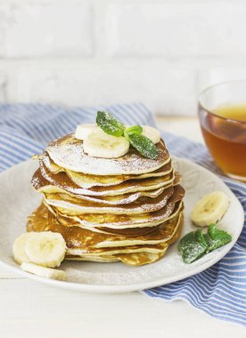 taze pişmiş krep muz beyaz tabak ve bardak çay ile 