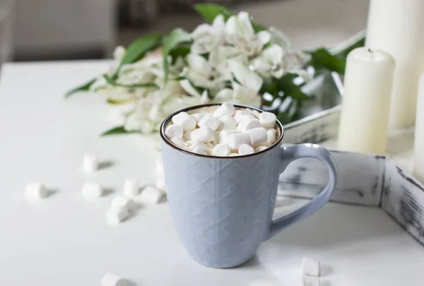 Niebieski kubek z kakao, Kawa, marshmallows w biały stół w stylu — Zdjęcie stockowe