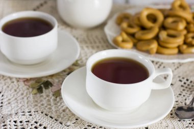 Beyaz bardak çay ve kraker vintage masa örtüsü ile masaya tabak